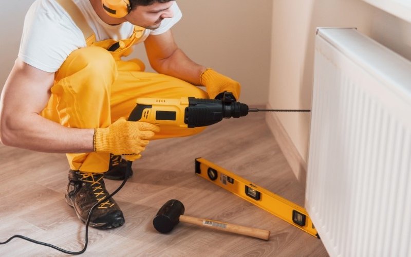 handyman-working-wall-indoors-drilling